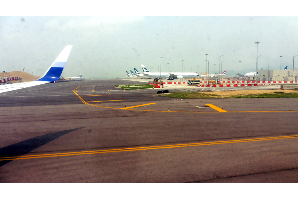 Four Cathay Pacific planes parked next to each other side by side 